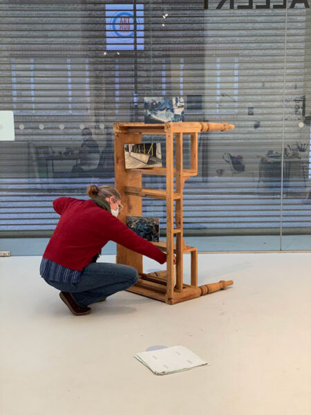 Incubator of Ideas - Marcia Teusink placing paintings on found table structure
